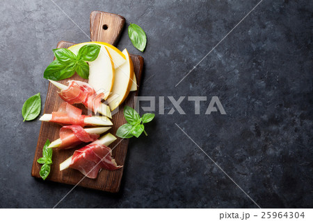 Fresh melon with prosciutto and basil Fresh melon with prosciutto and basil 25964304