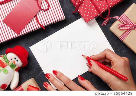 Female writing christmas greeting card and gifts Female writing christmas greeting card and gifts 25964428