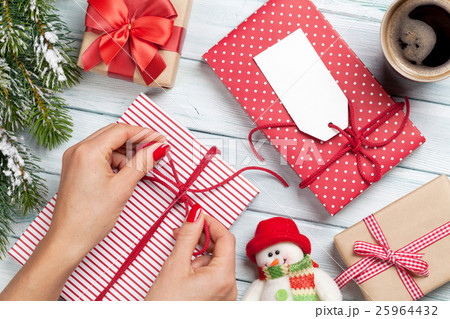Female hands wrapping christmas gift Female hands wrapping christmas gift 25964432