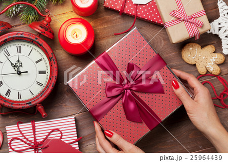 Female hands holding christmas gift Female hands holding christmas gift 25964439