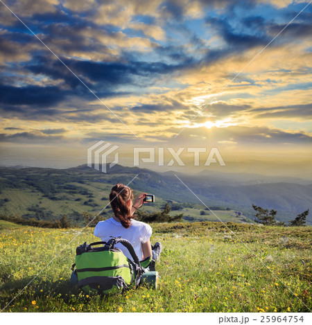 Female traveller with backpack making photo of mountain lanscape 25964754