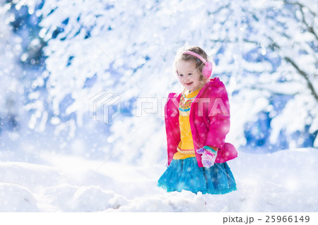 Little girl playing in snowy winter forest Little girl playing in snowy winter forest 25966149