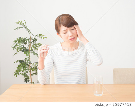 風邪を引いて熱をはかる女性 25977418