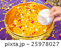 Water in bowl mixed with perfume and  flowers 25978027