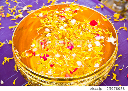 Water in bowl mixed with perfume and  flowers 25978028