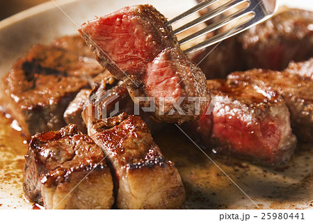 霜降り牛ステーキ フォークで切る断面 ジューシーな焼き加減 高級レストランの肉料理イメージ 霜降り牛ステーキ フォークで切る断面 ジューシーな焼き加減 高級レストランの肉料理イメージ 25980441