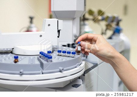 scientist holds an amber vial. 25981217