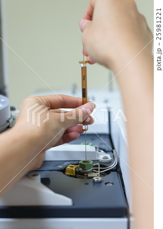 Scientist shooting sample in analytical instrument Scientist shooting sample in analytical instrument 25981221