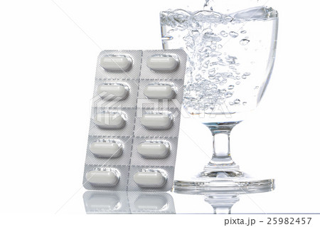 A pack of pills with a glass of water, isolated A pack of pills with a glass of water, isolated 25982457