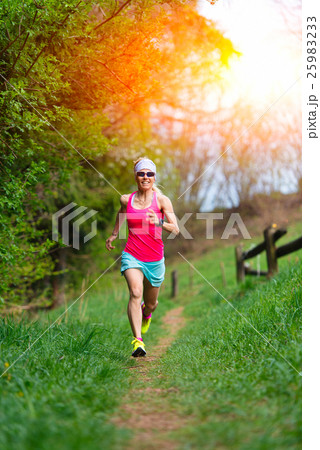 Girl athlete runs into the forest and meadow Girl athlete runs into the forest and meadow 25983233