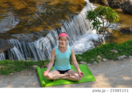 Middle aged woman doing yoga posture outdoor 25985151