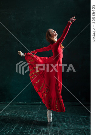 Ballerina posing in pointe shoes at black wooden 25986405