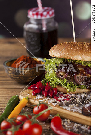 Fresh burger closeup on wooden desk background Fresh burger closeup on wooden desk background 25988872