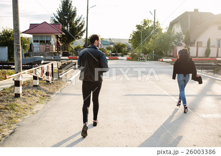 man and woman running to the railroad crossing 26003386