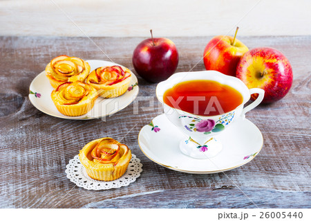 Cup of tea and small apple roses shaped pies 26005440