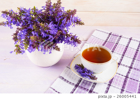Cup of tea on checkered napkin and purple flowers Cup of tea on checkered napkin and purple flowers 26005441