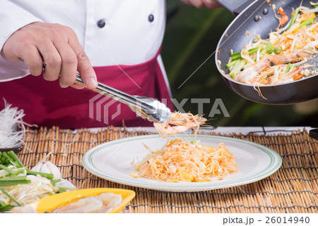 Chef fork over shrimp by tongs 26014940