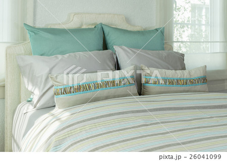 cozy bedroom with pillows and reading lamp 26041099