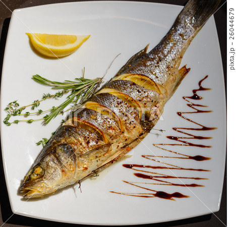 Oven-baked Sea bass with lemon and herbs Oven-baked Sea bass with lemon and herbs 26044679