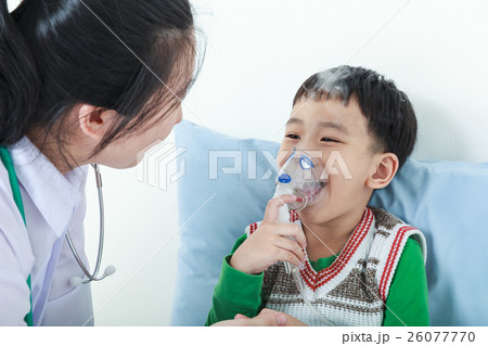 Boy having respiratory illness helped by doctor. Boy having respiratory illness helped by doctor. 26077770