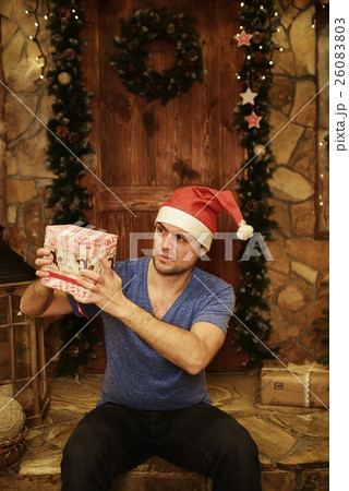 Young amusing man is surprised to Christmas gift Young amusing man is surprised to Christmas gift 26083803
