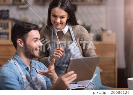 Delighted young couple making notes and using 26086126
