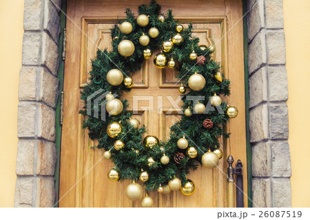 Christmas wreath with baubles and cones on a door. Christmas wreath with baubles and cones on a door. 26087519