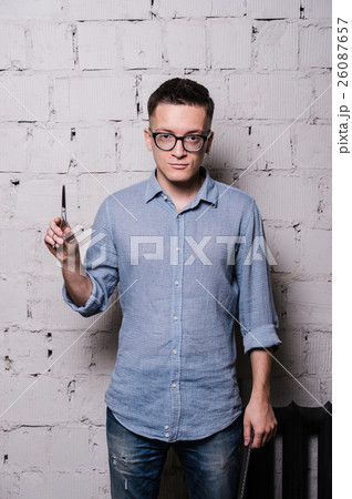 Portrait of young male hairdresser in glasses Portrait of young male hairdresser in glasses 26087657