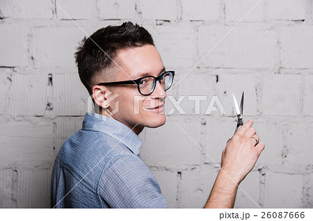 Young male hairdresser in glasses, posing with Young male hairdresser in glasses, posing with 26087666