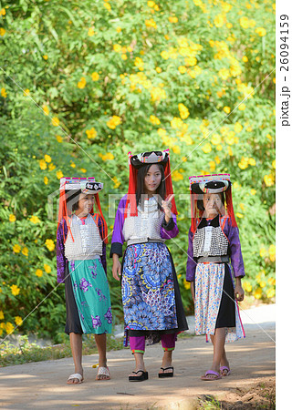 Three Asian Lahu girl in custom dress walking . 26094159