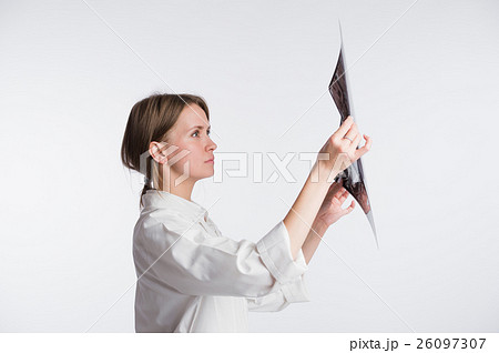 Female doctor examining an x-ray picture, back Female doctor examining an x-ray picture, back 26097307