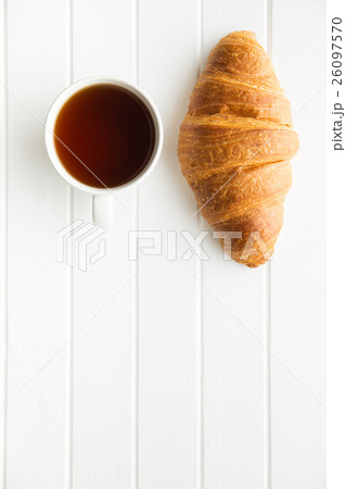 Tasty buttery croissant and cup of tea. Tasty buttery croissant and cup of tea. 26097570