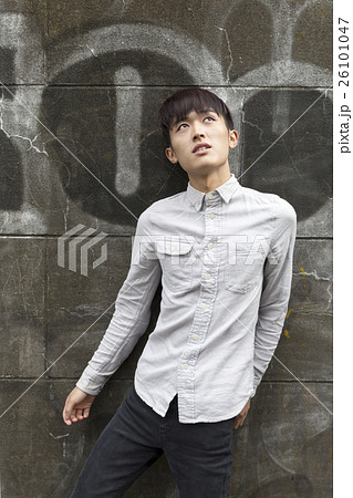 ファッションポートレート 男性 屋外 立つ 落書き 原宿 全身 横顔 見あげる 見つめるの写真素材