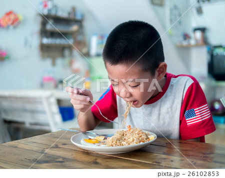 Happy Asian boy eating delicious noodle 26102853