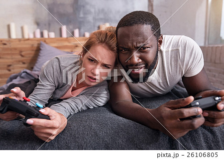 Amused couple playing video games in bedroom Amused couple playing video games in bedroom 26106805