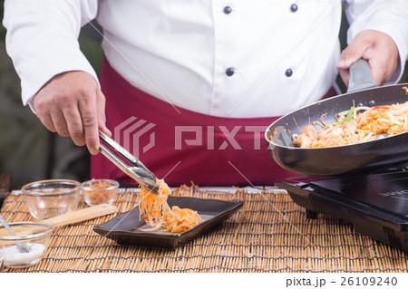 Chef fork over noodles by tongs 26109240