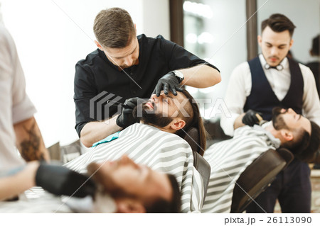 Barbers making a beard form for clients Barbers making a beard form for clients 26113090