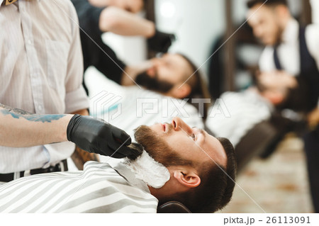 Barbers making a beard form for clients Barbers making a beard form for clients 26113091