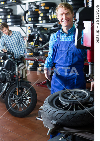 smiling technician man working with wheel for motorcycle smiling technician man working with wheel for motorcycle 26119106