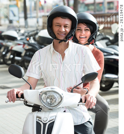 Mature couple driving petrol scooter . 26119478