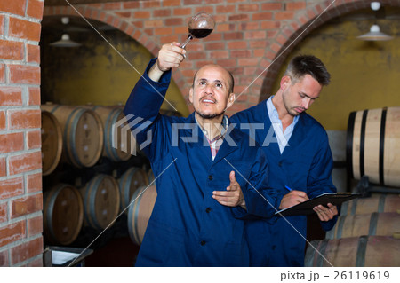 two winemakers with sample of wine in cellar. 26119619