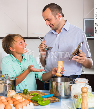 Father and teenage son cooking together. 26120702