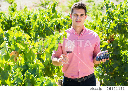 Adult farmer posing with wine and grape Adult farmer posing with wine and grape 26121151
