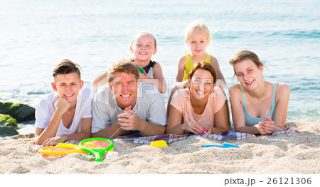 Glad family with four children lying on beach 26121306