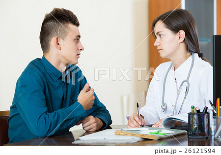 doctor receiving and questioning teen patient at office doctor receiving and questioning teen patient at office 26121594