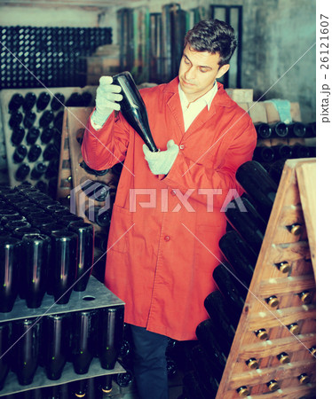 Wine maker taking care of seasoning bottles Wine maker taking care of seasoning bottles 26121607