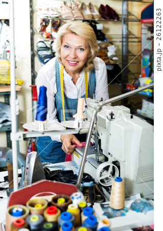 Mature woman sewing with professional machine Mature woman sewing with professional machine 26122263