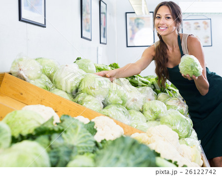 Woman seller wearing apron holding fresh cabbage head Woman seller wearing apron holding fresh cabbage head 26122742