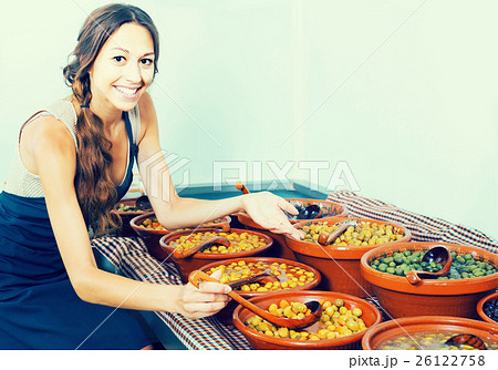 female seller picking olives with spoon in food store female seller picking olives with spoon in food store 26122758