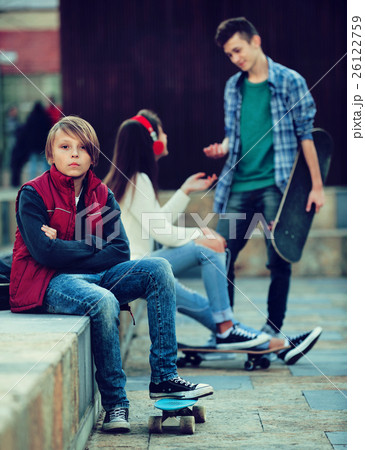 Offended boy and couple of teens apart 26122759